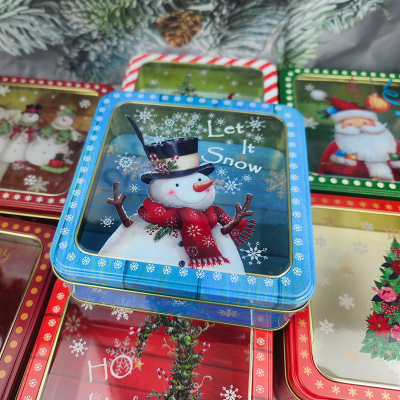Blue tin box with a window lid showing a Let It Snow snowman design